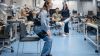 Dr. Xiaohui Zhang von der der TUM zeigt ihr Exoskelett, das älteren Menschen mit Hüftproblemen das Aufstehen erleichtert. (Quelle: Andreas Heddergott/TUM)